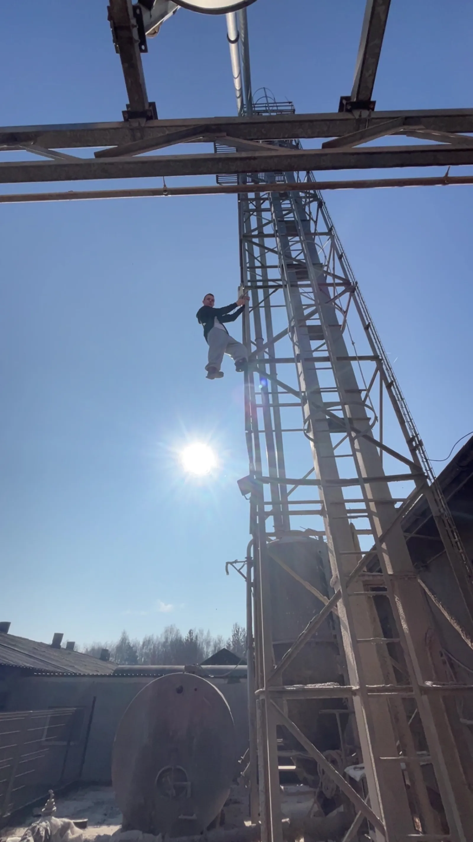 Certyfikowany technik podczas instalacji systemu zabezpieczeń na wieży przemysłowej.